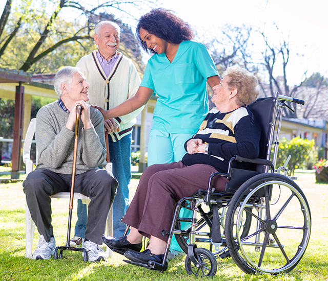Caregiver Outside with Happy Seniors